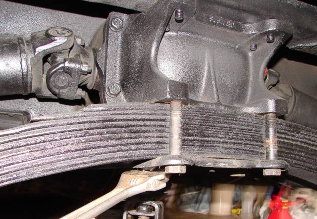 The four bolts holding the transverse spring to the differential