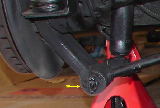 Removing the L-shaped bolt that holds the shock and strut